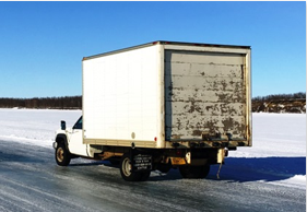 A box truck travels over the ice road.