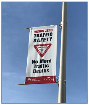 Photo shows a street banner that reads: Vision Zero Traffic Safety: No More Traffic Deaths.