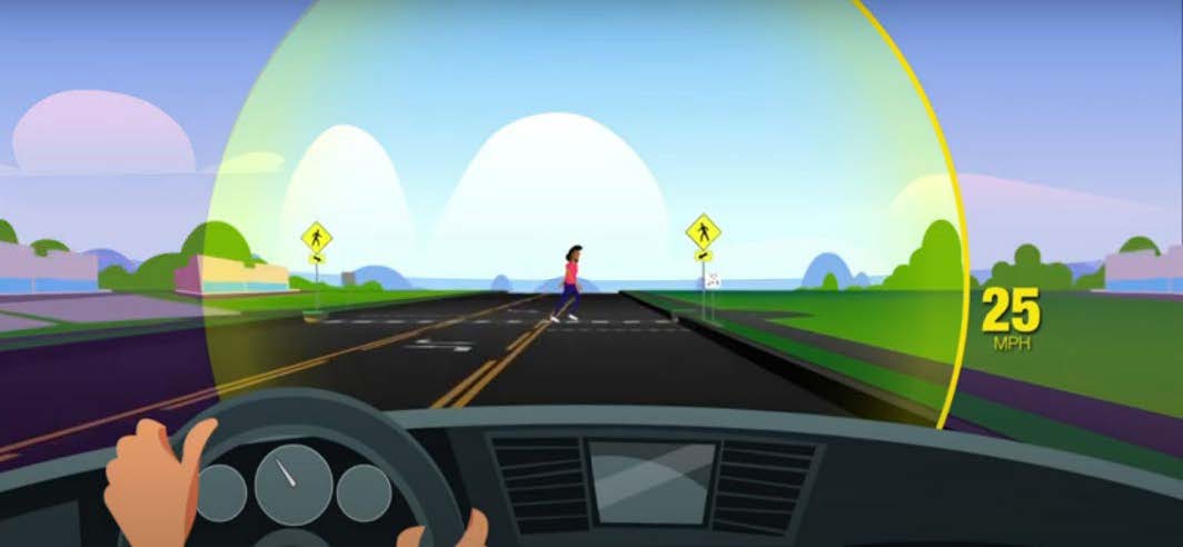 Screenshot shows the view of a driver approaching an intersection with a pedestrian in a crosswalk.