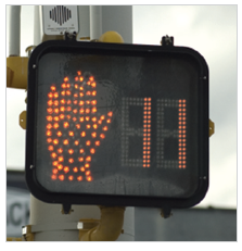 Figure 28. A picture of a countdown pedestrian signal; the signal displays an orange upraised hand and the number 11.