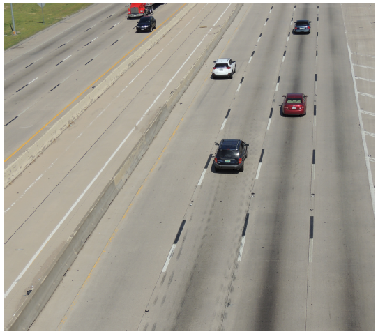 Figure 57. A picture of a section of eight-lane freeway with concrete surface on which the traditional white broken lane lines are supplemented by black broken lane lines.  The black lines are immediately downstream of the white lines to provide contrast to the white markings.