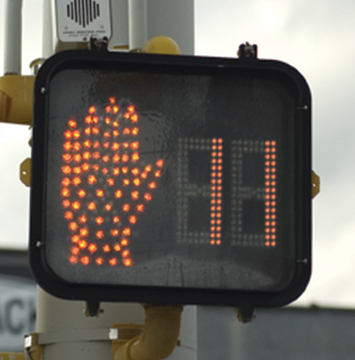 Figure 28. A picture of a countdown pedestrian signal; the signal displays an orange upraised hand and the number 11.