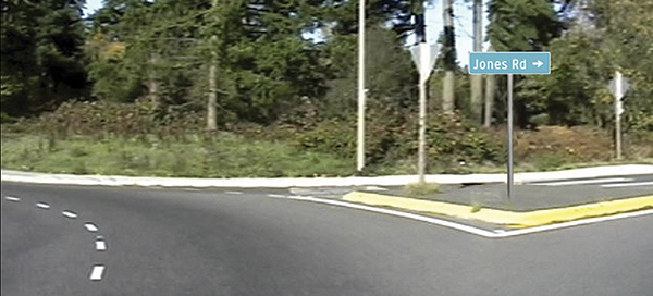 Figure 86. A picture of an departure from a roundabout with a sign reading JONES RD (right arrow) superimposed on the splitter island in the picture.