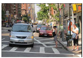 Image shows a crosswalk with intersection daylight (a blocked out parking space allowing for increased visibility)