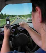 Photo showing a driver driving while using a cellphone.
