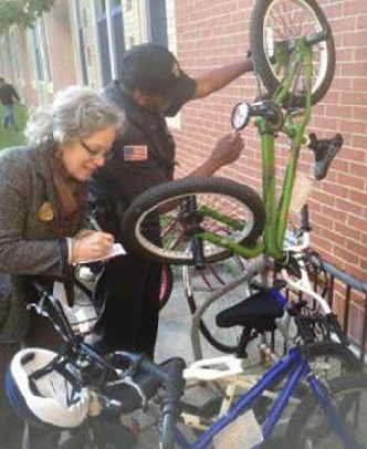 Photo: Caption: Figure 19: Bike Newport Staff Engage with Local Enforcement and Other Agency Staff on a Range of Bicycle Issues, Including Efforts to Prevent Bike Theft.