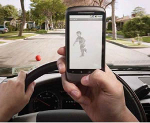 Photo: Distracted Driver Campaign. Person taking a picture with a cell phone while driving.
