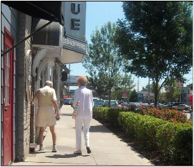 Photo of elderly couple walking down a side walk