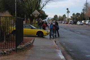 A car blocks the sidewalk, causing children walking to school to step in the street in the Phoenix audit corridor.