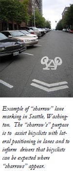 Example of “sharrow” lane marking in Seattle, Washington. The “sharrow’s” purpose is to assist bicyclists with lateral positioning in lanes and to inform drivers that bicyclists can be expected where “sharrows” appear.