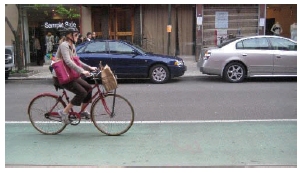 Photo of a bicyclist in a bike lane on a downtown street.