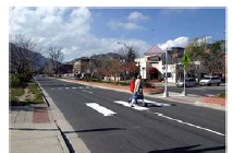 Photo of a mid-block pedestrian crossing with a median refuge.