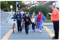 A crossing guard holding traffic while children walk in a crosswalk on their way to school