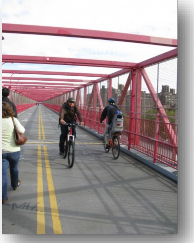Photo: Bicyclists and pedestrians cross a bridge.