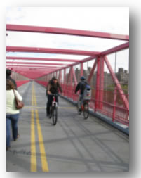 Photo of bicyclists and pedestrians on a bridge.