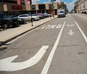 Photo.  A bike lanes placed to the left of a right-turn lane, which minimizes the opportunity for right hook crashes and permit cyclists to ride through the intersection.
