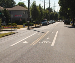Photo.  A roadway through a residential area with two bicycle left-turning bays at an uncontrolled intersection.