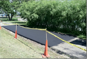 Figure 3. Asphalt is commonly used for shared use paths, but is less commonly used for sidewalks in the United States. Above is a section of shared use path after a repair in Madison, Wisconsin.