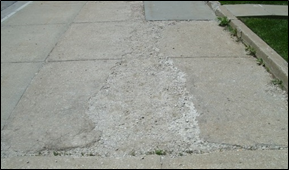 Title: Photo of spalling – Description: Slabs whose surface is granular or if a chunk of the sidewalk surface greater than 2" in width has broken out, and the result is a hole frac12" or deeper