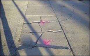 Photograph of a cracked sidewalk panel