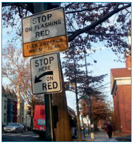 Signs at the site of a PHB advise drivers to stop at a specified location during the flashing red phase then to proceed when clear.
