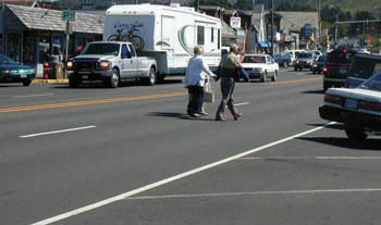 Two pedestrians jaywalking across a street