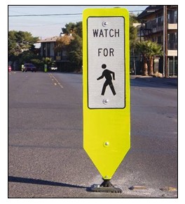 Photo of an in-street pedestrian warning sign that reads 'watch for pedestrians.'