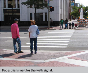 Pedestrians wait for the walk signal.