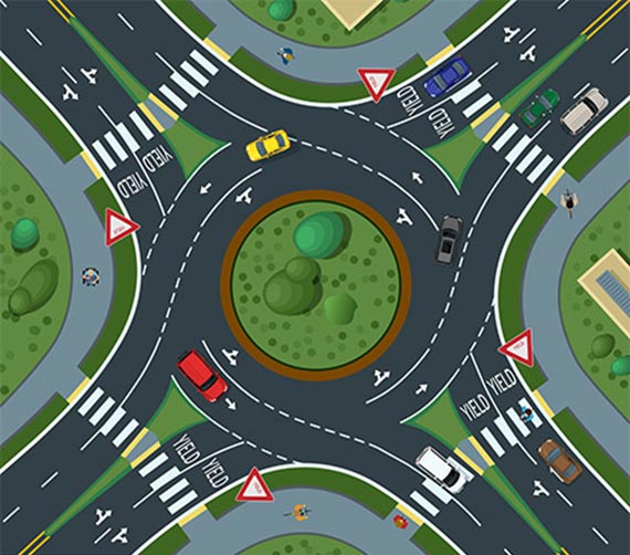 Illustration: This illustration shows a multilane roundabout. The roundabout has four approach legs. Each approach leg is a four-lane divided highway. Each approach leg yields to circulating traffic within the roundabout and features a high visibility crosswalk. Several pedestrian safety countermeasures are visible, including tactile curb ramps and multiuse path facilities.