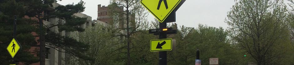Flashing beacons at a crosswalk are indicating that pedestrians may be in the area.