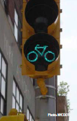 A green-yellow-red signal head designed for assisting bicyclists, it has the shape of a bike in the illuminated green lens.