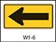 Figure.  Figure shows sign W1-6, the one direction large arrow sign.  It is a large black arrow pointed left on a yellow background.