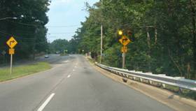 Photo.  A roadway is shown with a horizontal alignment sign on each side of the roadway.