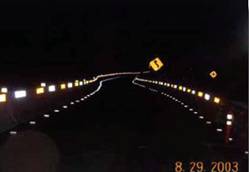 Photo.  Photo is of linear reflectorization effect of reflective sheeting placement on guardrails.  These are night photos and show a high degree of visibility of the curves due to this application
