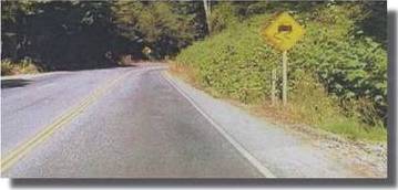 Photo.  Photo shows a rural road where the curve has been treated with multiple treatments as indicated in the photo caption.