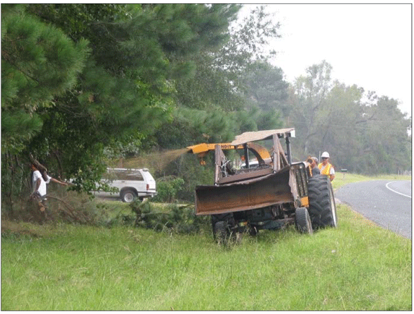 Photograph of a brush chipper being used to mow and remove brush from the clear zone of a horizontal curve.