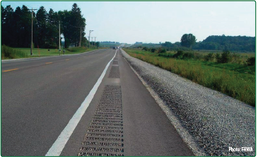 Bicyclist riding over gravel and debris on the narrow shoulder of a roadway as cars pass. Source: FHWA