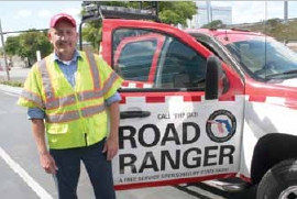 Photo of a safety patrol operator standing by his Road Ranger service patrol vehicle.