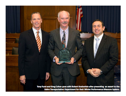 Tony Furst and Greg Cohen pose with Robert Koeberlein after presenting an award to the Idaho Transportation Department for their Winter Performance Measure System.
