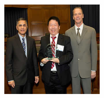 Victor Mendez and Tony Furst pose with Peter Hsu after presenting an award to Florida Department of Transportation – District 7 (Tampa Bay Area) for Advanced Lighting Measurement System.