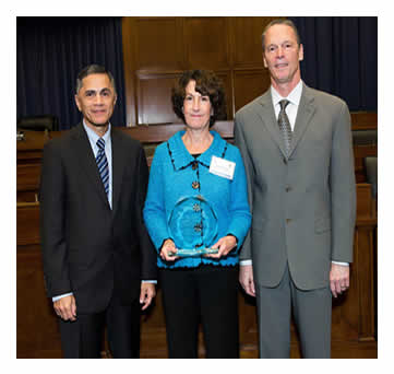 Victor Mendez and Tony Furst pose with Kathleen Davis after presenting an award to Washington State Department of Transportation for 2014 County Safety Program.
