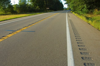 A rural two-lane roadway treated with center line and shoulder rumble strips.