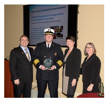 Photo: Greg Cohen, Brandye L. Hendrickson and Beth Alicandri pose with Fire Chief John Lehman after presenting an award to Michigan's Department of Transportation for its Improved Incident Scene Safety with Partnerships.