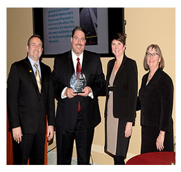 Photo: Greg Cohen, Brandye L. Hendrickson and Beth Alicandri pose with Wayne Sandberg after presenting an award to Minnesota's Department of Transportation for its Implementation of Data-Driven Safety Solutions.