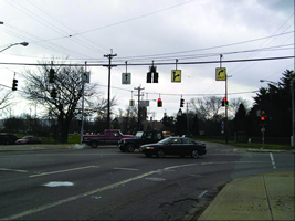 The photo shows the intersection of Winton Road and Spring Grove Avenue: a signalized intersection with dedicated right- and left-turn lanes (signed) and a concrete sidewalk.