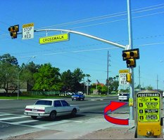 The photo shows a typical HAWK pedestrian signal, with an inset showing the sign that advises waiting pedestrians how to operate the signal.