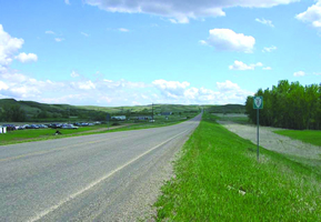 The photo shows BIA 3 at the intersection with ND 24, south of Fort Yates, ND: a two-lane rural road with narrow paved shoulders.