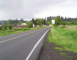 The photo shows Ward Road near Davis Road: a two lane rural road with narrow paved shoulders in a rural environment.