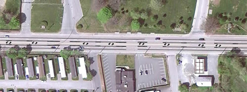 An aerial view of the four-lane roadway with the two-lane roadway conversion concept overlaid.