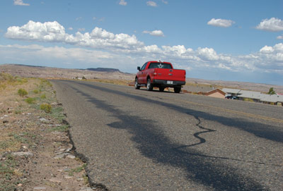 Page 28 photo. This photo shows a truck traveling on a roadway which has noticeable cracks and deterioration. 